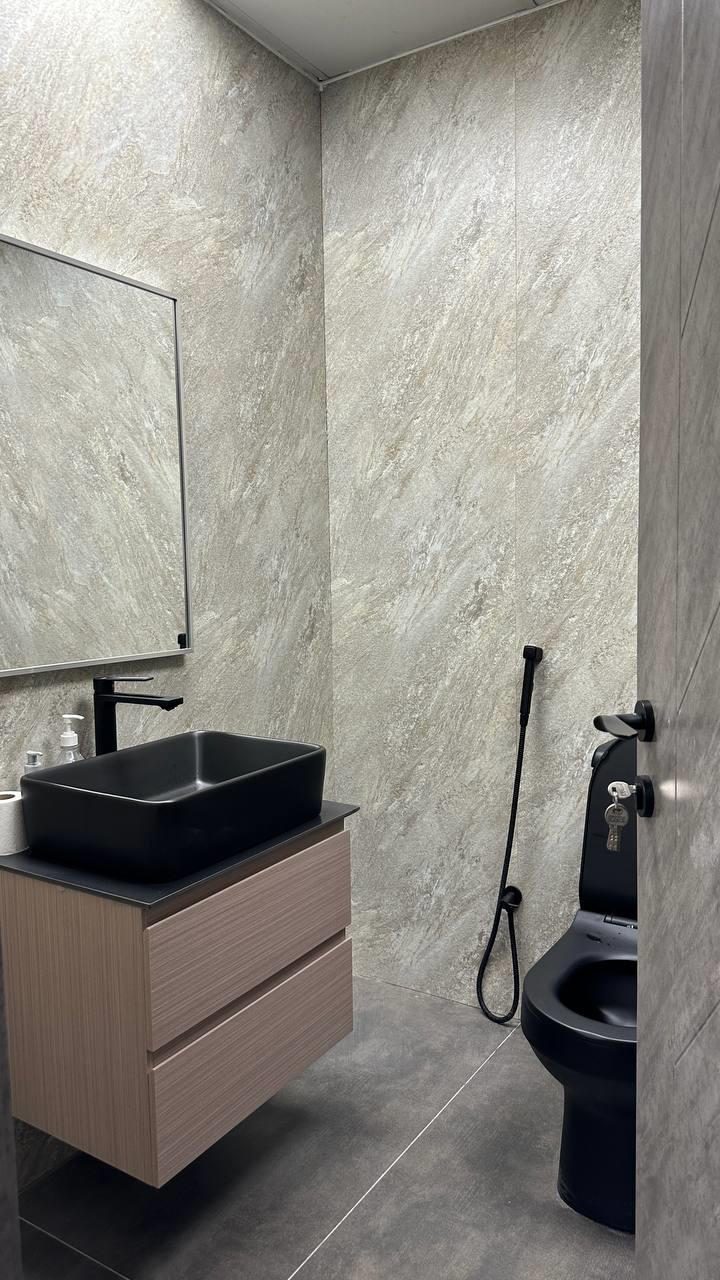 Powder room clad in figured marble with a floating basin