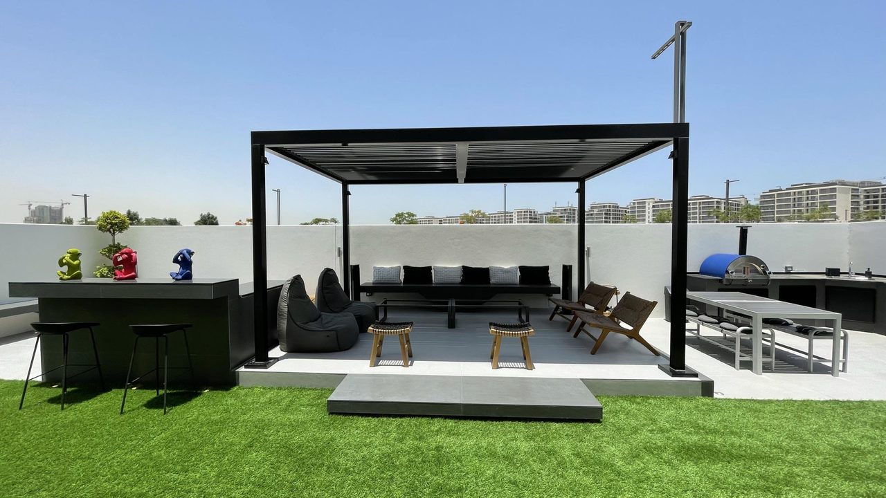 Landscaped villa garden with a shade structure, lawn and seating
