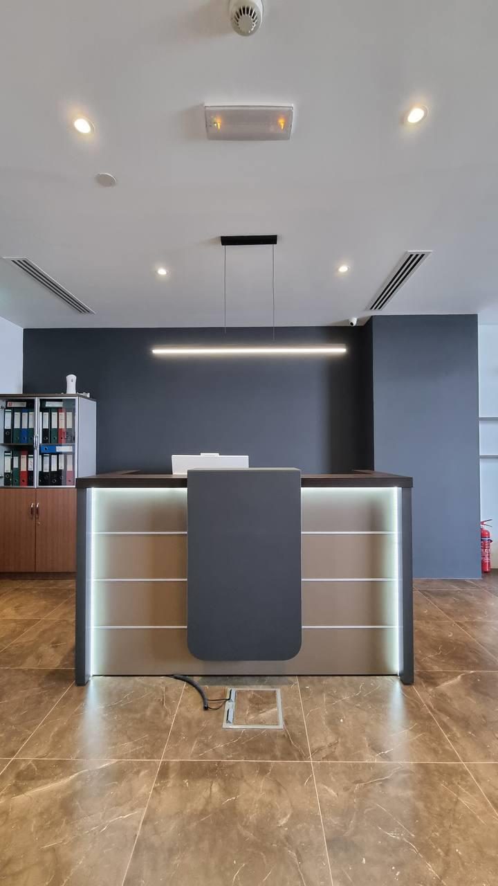 Office reception with a backlit stone counter and warm timber flooring