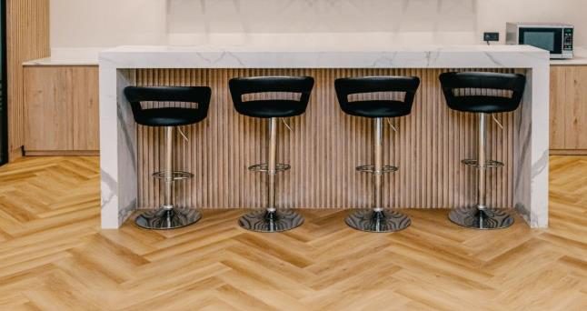 Kitchen bar with fluted timber panelling and counter stools