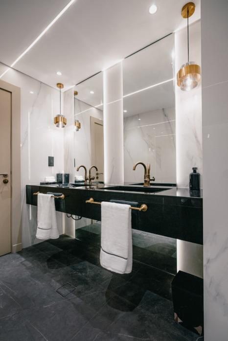 Bathroom in green marble with brass fittings and a walk-in shower