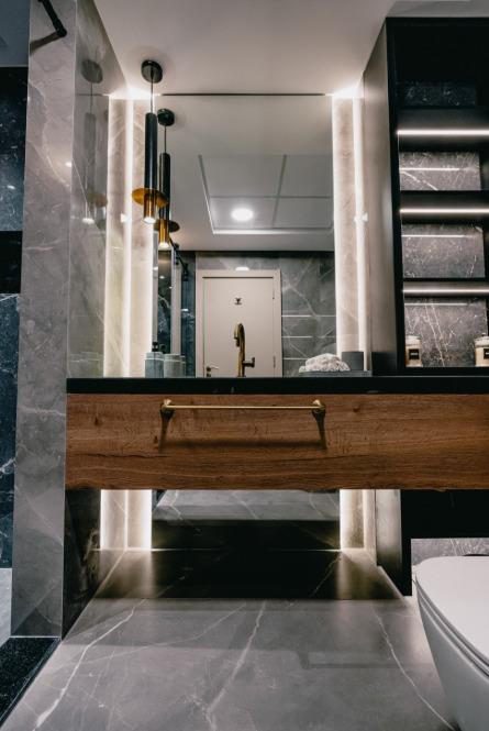 Villa bathroom clad in book-matched marble with a floating timber vanity