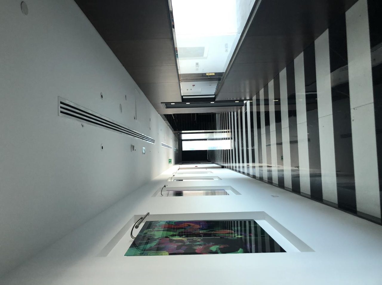 Gallery corridor with an inlaid floor and linear lighting