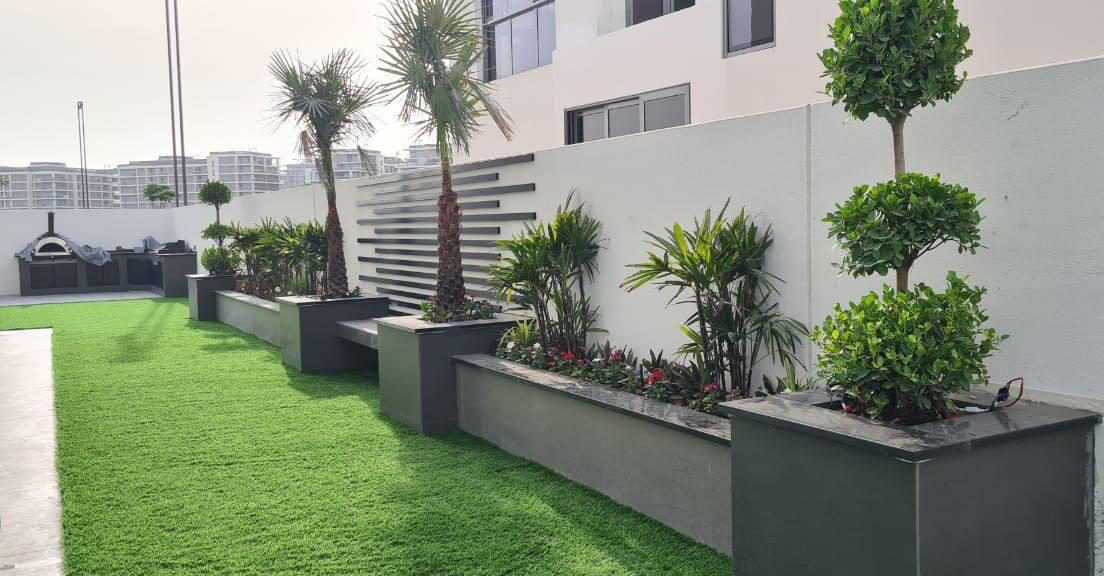 Raised planters with mature shrubs framing a private villa garden
